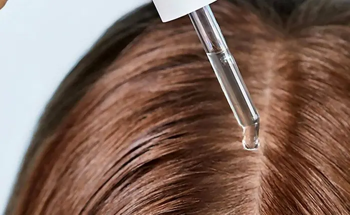 خانم در حال استفاده از بهترین سرم تقویت کننده مو 9845689764